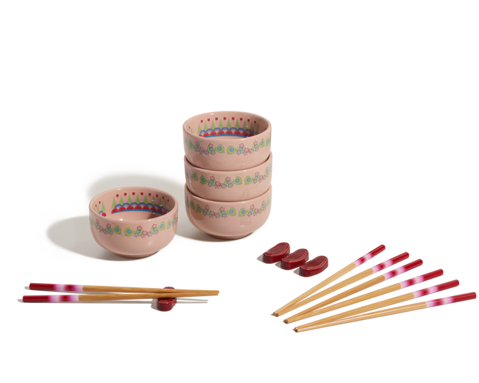The Rice Bowl Set includes four pink, floral-patterned bowls stacked beside two more bowls, six pairs of pink-tipped chopsticks, and four red chopstick rests, all displayed on a white background.