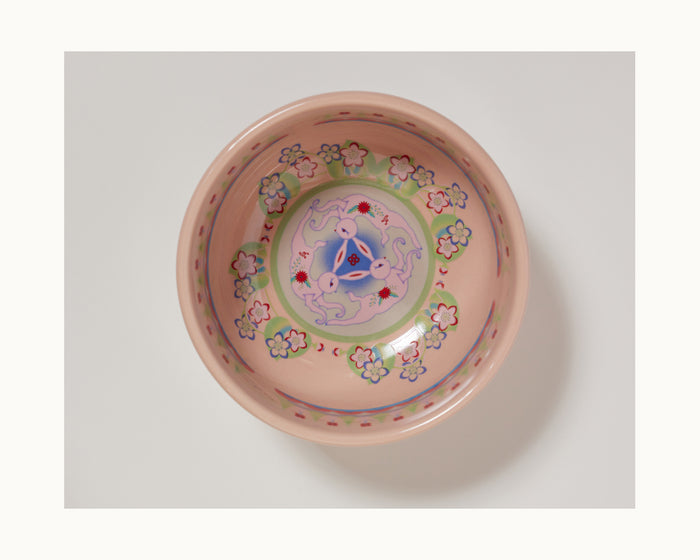 A pink ceramic rice bowl from the limited-edition Rice Bowl Set features a floral rim pattern and colorful abstract center, celebrating Lunar New Year tableware, displayed on a white background.