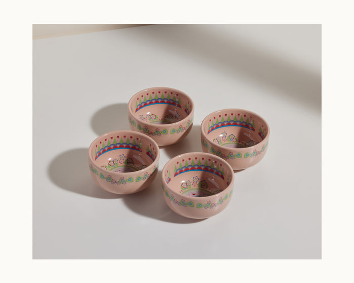 The Rice Bowl Set includes four pink ceramic bowls with colorful decorative patterns, inspired by Lunar New Year tableware, arranged together on a white surface.