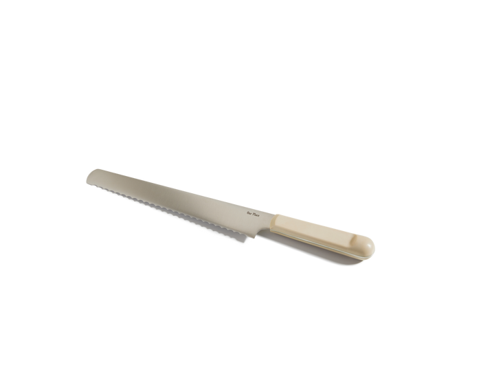 The Serrated Slicing Knife, featuring an ultra sharp serrated blade and a beige handle, is displayed on a white background.
