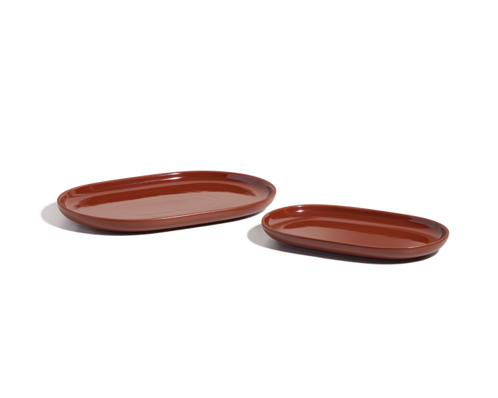 Two reddish-brown ceramic Serving Platters in oval shapes and different sizes are displayed on a white background, ideal for adding elegance to your tableware set.