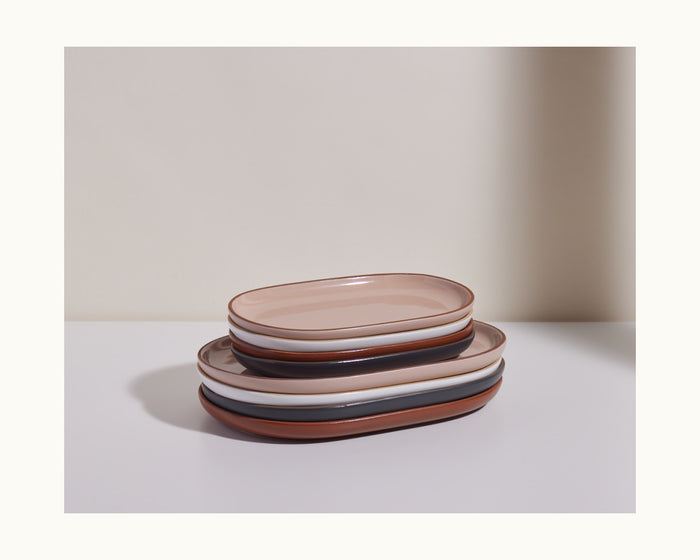 A set of six oval Serving Platters in neutral ceramic tones, arranged on a white surface with a light backdrop, ideal for enhancing any tableware set.