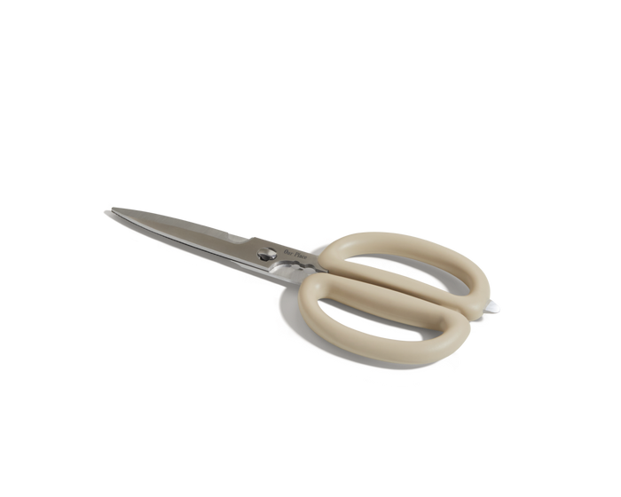 The Shear Genius kitchen shears, made of stainless steel with beige plastic handles, are displayed on a white surface to highlight their multifunctional design.