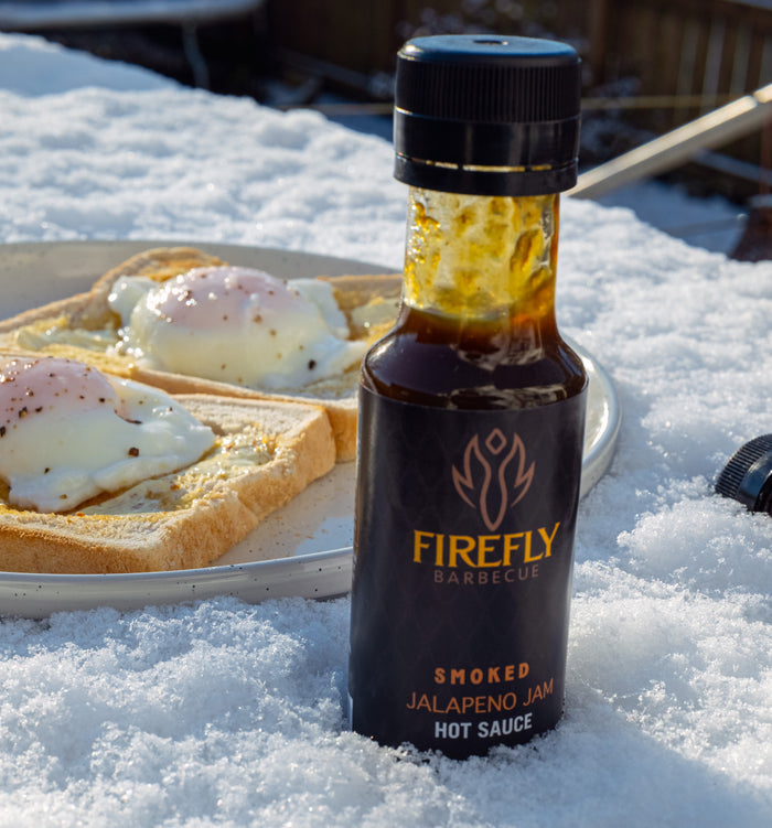 Barbecue sauce bottle with black cap on snowy surface