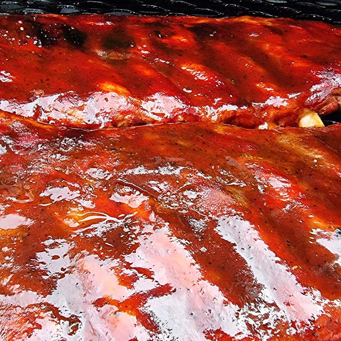 Grilled ribs glazed with Sweet Texas BBQ Sauce by Firefly, showcasing a rich, glossy finish perfect for enhancing BBQ dishes with sweet tangy flavor.