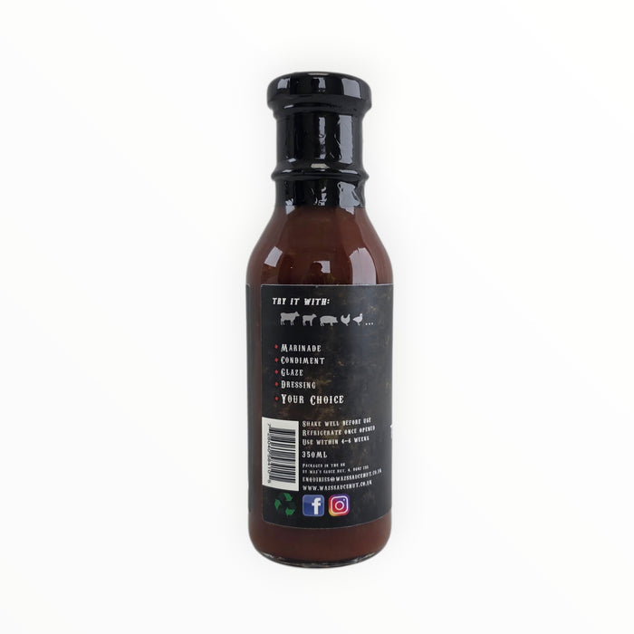 Waz's Sauce bottle with black cap on rustic wooden surface
