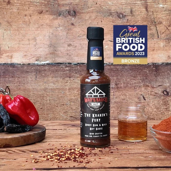 Waz’s Sauce hot sauce bottle on wooden background with award badge