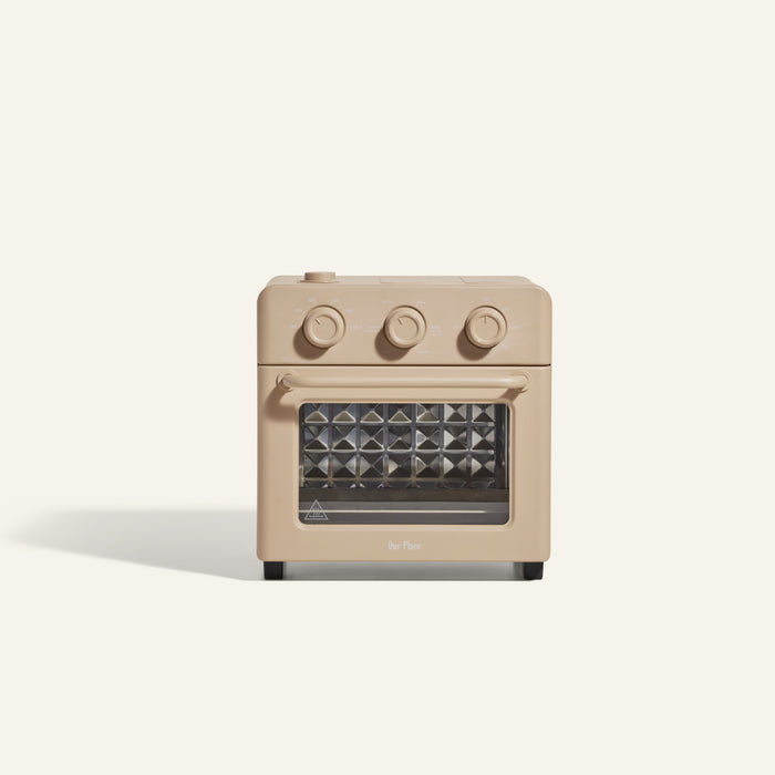 The Wonder Oven is a compact toaster oven with knobs, a glass window, and air fryer functionality for versatile cooking.